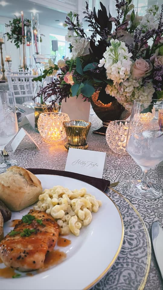 wedding designed table with a plate of food and name card on it